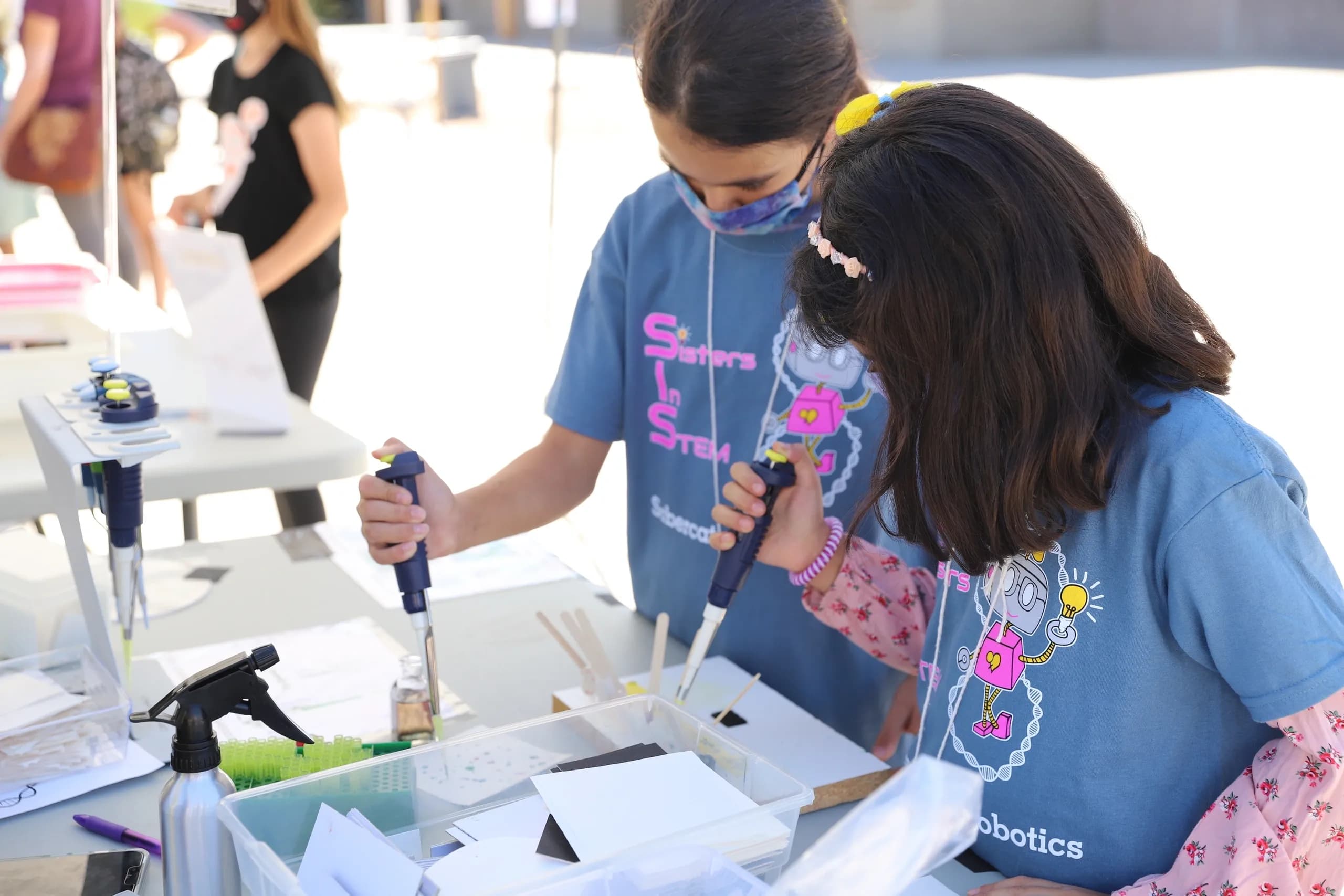 2 young girls using synringes in a STEM experiment at SiS event